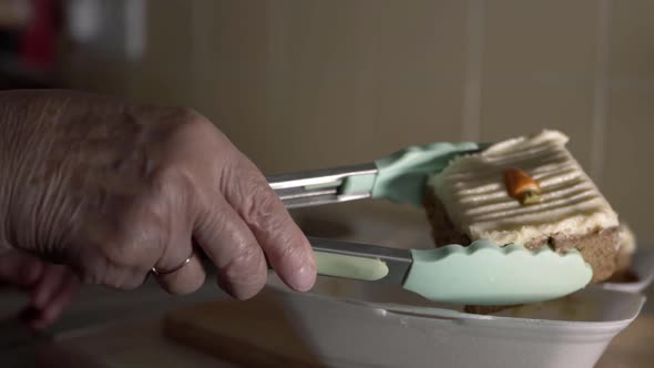 Hands of elderly lady serving carrot cake close up shot