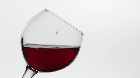 Close Up of a Drop Falling in Glass with Red Wine. Rose Wine on White Background