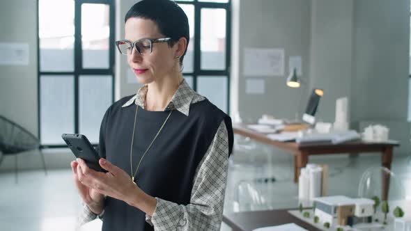 Mid Age Business Lady Using Smartphone in Office