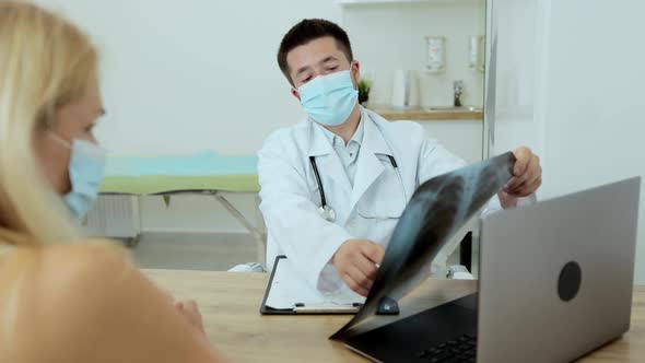 Young Man Doctor in a White Coat Communicates with Patients Portrait