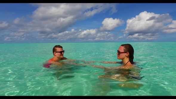 Two lovers suntan on idyllic sea view beach adventure by blue sea and white sandy background of the 