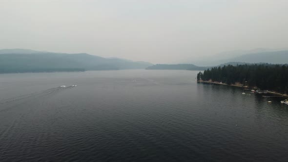 Zoom-out drone shot of Lake Payette in McCall, Idaho on a smoky summer day. This stunning 4K cinemat