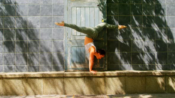 Young ballerina dancer practicing handstand against wall 4k