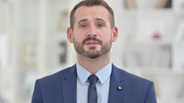 Portrait of Businessman Waving on Video Call