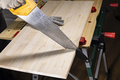 side view of sawing wooden board with hand saw - PhotoDune Item for Sale