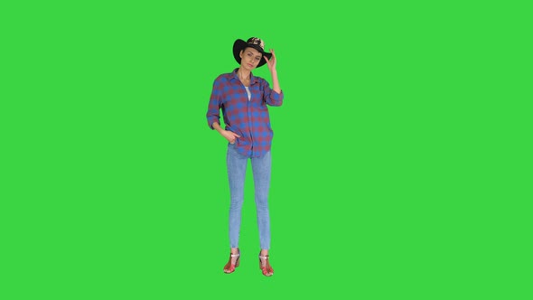 American Woman Cowgirl Posing To Camera on a Green Screen, Chroma Key.
