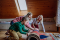 Boy with Down syndrome with his mother and grandmother rolling up the carpet at home - PhotoDune Item for Sale