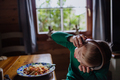 Boy with Down syndrome having lunch with headphones and looking at camera at home - PhotoDune Item for Sale