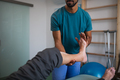 Close-up of physiotherapist exercising with senior patient's leg in a physic room - PhotoDune Item for Sale
