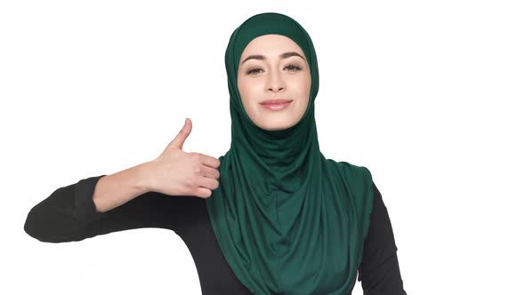 Portrait of Young Religious Woman in Traditional Niqab Showing Thumb Up and Being Satisfied Over