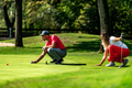 Young couple on a golf course, reading green - PhotoDune Item for Sale