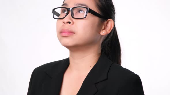 Confident Asian businesswoman looking up on white background in studio