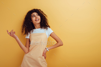 ith hand on hip on yellow background