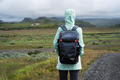 Woman with backpack and green jacket on travel in Iceland - PhotoDune Item for Sale
