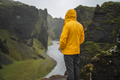 Man in yellow jacket visit the Fjadrargljufur Volcanic Canyon in Iceland on moody overcast and rainy - PhotoDune Item for Sale