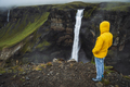 A man in yellow jacket enjoying Haifoss waterfall on rainy overcast weather. Highlands of Iceland - PhotoDune Item for Sale