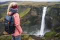 Woman with backpack and lilac jacket enjoying Haifoss waterfall of Iceland Highlands in - PhotoDune Item for Sale