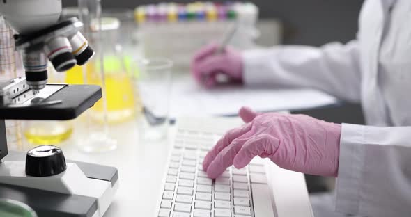 Scientist in Gloves is Typing on Keyboard in Laboratory
