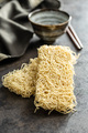Instant noodles. Uncooked chinese noodles on black kitchen table. - PhotoDune Item for Sale
