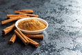 Dry cinnamon sticks and cinnamon powder on black table. Cinnamon spice. - PhotoDune Item for Sale