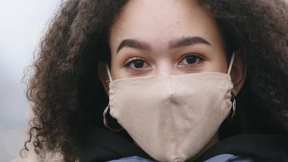 Gorgeous Dark Skinned Black Young Woman with Afro Hairstyle Wearing Protective Mask From COVID Virus