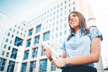 businesswoman who carries a laptop on the background of a business center.