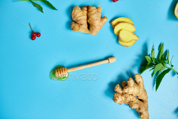 ing foods ginger, lemon,  honey,  guelder rose, mint on blue background Top view, copy space