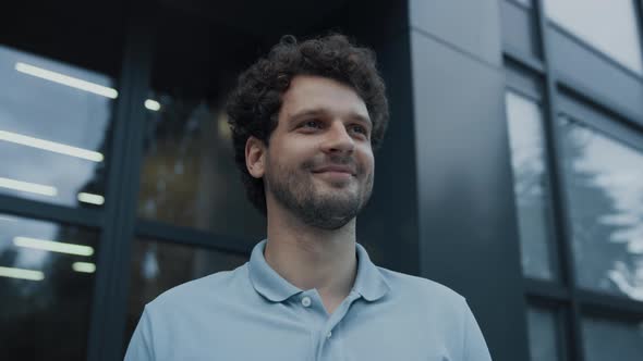 Closeup Smiling Man Teacher Standing at School Entrance Looking Distance