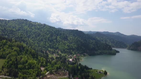 Aerial Downwards pan of lanscape shot of valley with lake and woodland