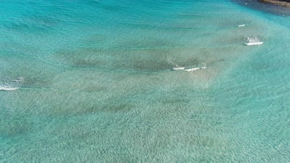 Extreme Wide Shot of Sandy Sea Bottom with Turquoise Waves of Mediterranean Sea Over It. Aerial View