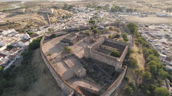 Aerial above view of hilltop defensive Castro Marim castle surrounded by parish village.