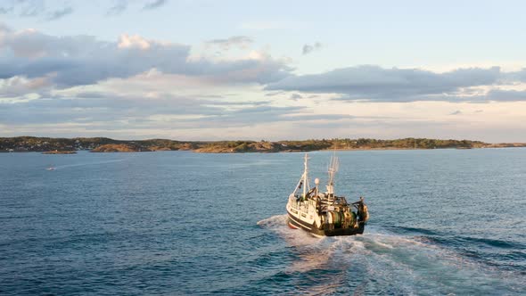 Aerial View Of Commercial Fishing Boat Going Home After Catching Fish In The Ocean In Norway. - rear