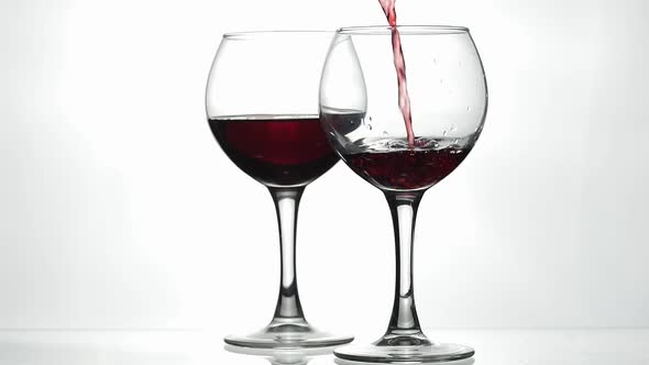 Rose Wine. Red Wine Pour in Wine Glass Over White Background. Slow Motion