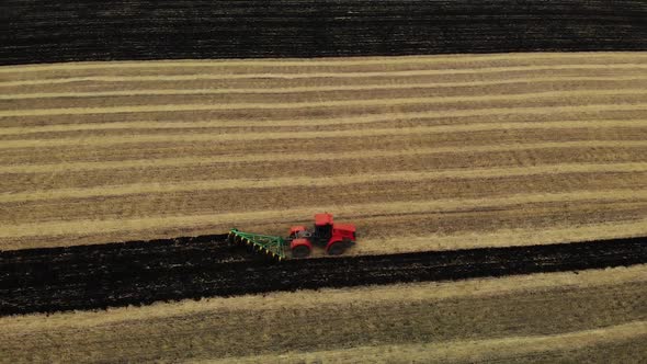 Tractor Plowing Fields, Preparing Land for Sowing. Aerial View. Farmer in Tractor Preparing Land in