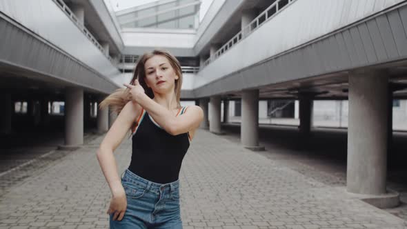 Young Dancing Woman Is Performing Modern Vogue or Hip Hop Dance, Freestyle in Industrial Urban