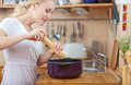 young woman cooking in the kitchen- adding salt and pepper into the pot seasoning concept - PhotoDune Item for Sale