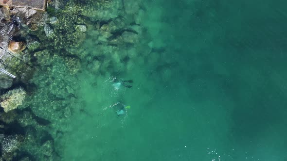 Unique view of scuba divers below the water exploring a man-made artificial reef built for the city