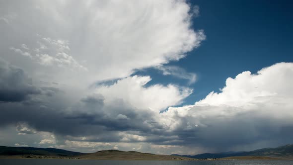 Timelapse of clouds over lake in wide open valley