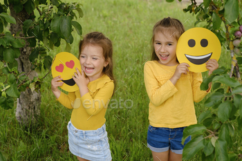 emoji and laugh merrily standing under a tree in the park. A warm summer day in nature