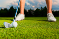 closeup shot of golf ball with golf club right before tee off with player legs in background - PhotoDune Item for Sale
