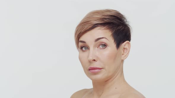 Close-up of middle aged mature woman over white background.