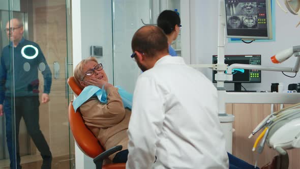 Woman with Toothache Talking with Orthodontic