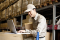 Male Chinese warehouse worker using a laptop - PhotoDune Item for Sale
