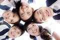 Cute schoolchildren huddling in a circle smiling happily - PhotoDune Item for Sale
