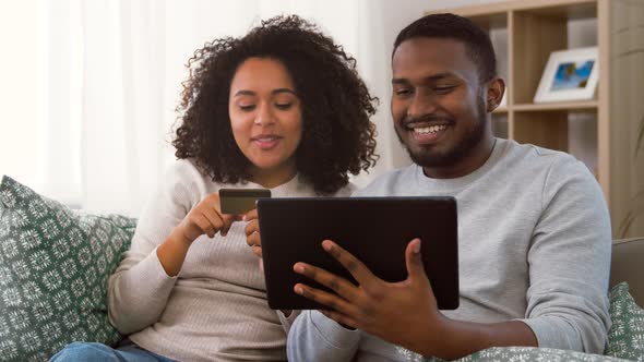 Couple with Tablet Pc and Credit Card at Home