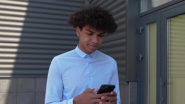 Young Businessman Walking on the Street Texting