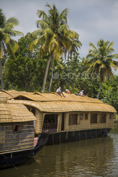 an at backwaters in Kerala, India. The backwaters are an extensive network of 41 west flowing interlocking rivers, lakes and canals that center around Alleppey, Kumarakom and Punnamada.