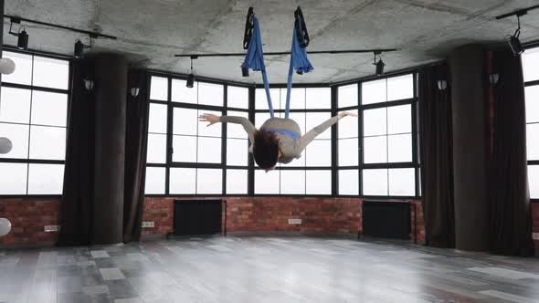 Woman Falling Down During Fly Yoga Exercise with Hammock