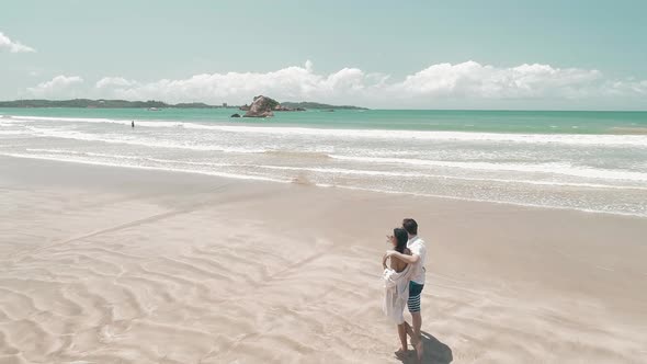 Honeymooners Standing On A Sandy White Tropical Beach