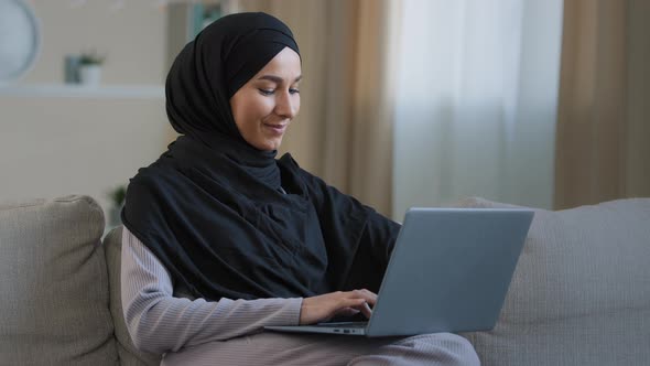 Happy Arab Woman Muslim Young Girl Woman Freelancer Creator in Hijab Sit at Home Chatting with